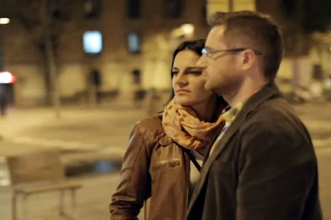 Young couple standing and looking around in night city, steadycam shot Stock-Footage 36660351