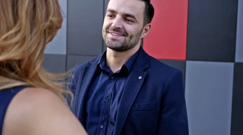 Young couple  standing and talking in front of modern building. Romantic meeting Stock Footage 55893217