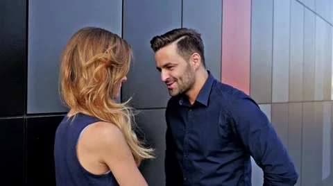 Young couple  standing and talking in front of modern building. Romantic meeting Stock Footage 56304194