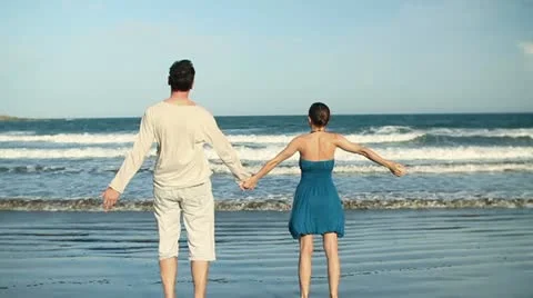 Young couple standing hand in hand on the beach , slow motion HD Stock Footage 10872672