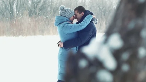 Young couple standing hugging in a winter forest Stock Footage 84989204