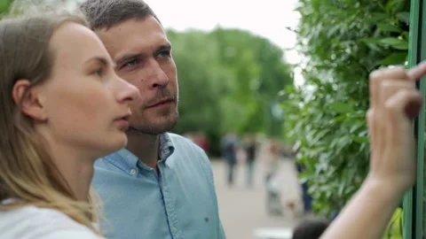 A young couple standing at a large display with advanced digital technology. A Stock-Footage 136082541