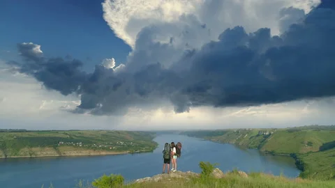 The young couple standing on the mountain top above scenic river Stock Footage 159840463