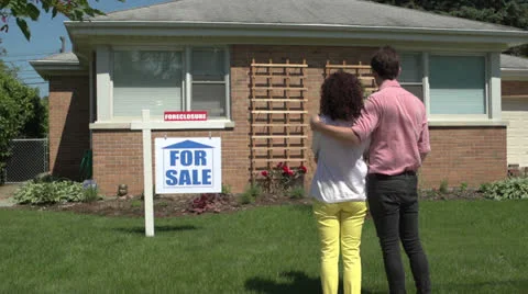 Young couple standing outside a foreclosed house, wide dolly. Stock Footage 24756449