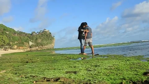 A young couple is standing on Pok Tunggal beach Stock Footage 275271653