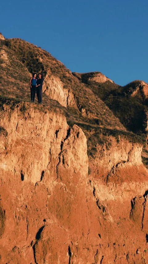 The young couple standing on the sandy mountain top Video stock 242134038
