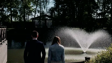 Young couple standing with their backs to the camera and looking at nature Stock Footage 142948429