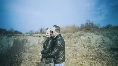 A young couple stands on the edge of a cliff on the shore of a beautiful sea bay Video stock 87918637