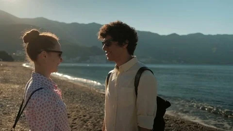 Young couple stands on the sandy store of sea in summertime. Stock Footage 78511376