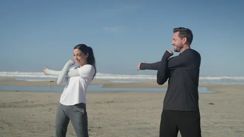 Young Couple Stretching on the Beach Stock Footage 233386563
