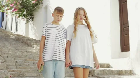 Young couple strolls hand in hand down stone steps in picturesque tourist t.. Video stock 286992072