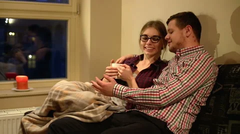 Young couple of students sitting on sofa and laughing Stock Footage 60896730
