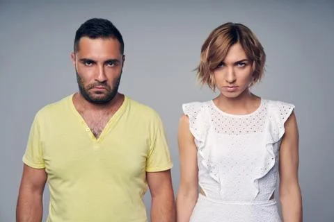 Young couple in studio standing with expression of disgust Stock Photos