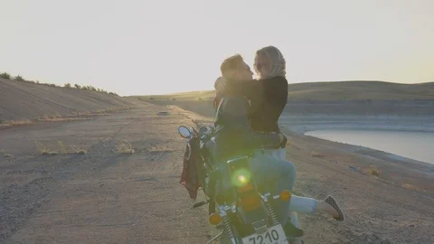 Young couple at sunset on a motorcycle Stock Footage 87167697