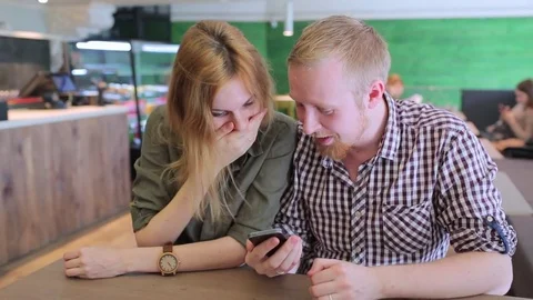 Young couple surfing the web looking at photos on mobile phone Stock-Footage 74459384