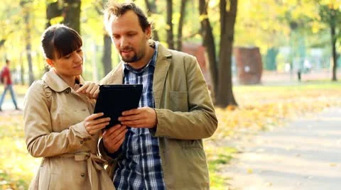 Young couple with tablet computer in autumn park Stock Footage 8950675