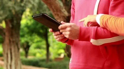 Young couple with tablet computer in the park, steadicam shot Vídeos de archivo 10854219