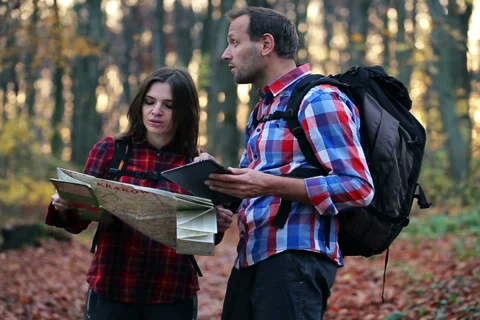 Young  couple with tablet looking for direction in autumn forest NTSC Stock Footage 43771042