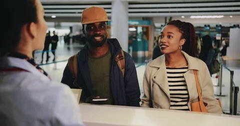 Young couple taking boarding passes at airport check-in desk Vídeos de archivo 90339934