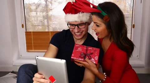 Young couple taking pictures using tablet pc. Christmas time. 50 fps. Stock Footage 57369542