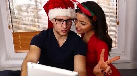 Young couple taking pictures using tablet pc. Christmas time. 50 fps. Stock Footage 57369574