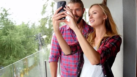 Young couple taking self-picture on their new apartment balcony. Stock Footage 55085335