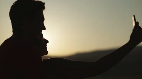 Young couple taking selfie at sunset in slow motion Stock Footage 53280622