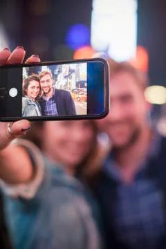 Young couple taking selfie while sightseeing in Times Square, New York City Stock Photos