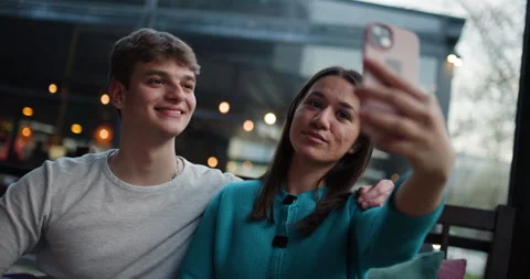 Young Couple Taking Selfies and Enjoying Coffee at a Cafe Vídeo Stock 343029919