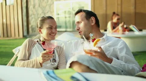 Young couple talking and drinking exotic cocktails  HD Stock Footage 10901721