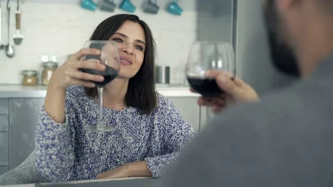 Young couple talking and drinking wine by table at home, 4K Stock Footage 69749257