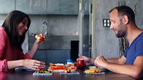 Young couple talking and drinking during breakfast at home 스톡 동영상 76695594