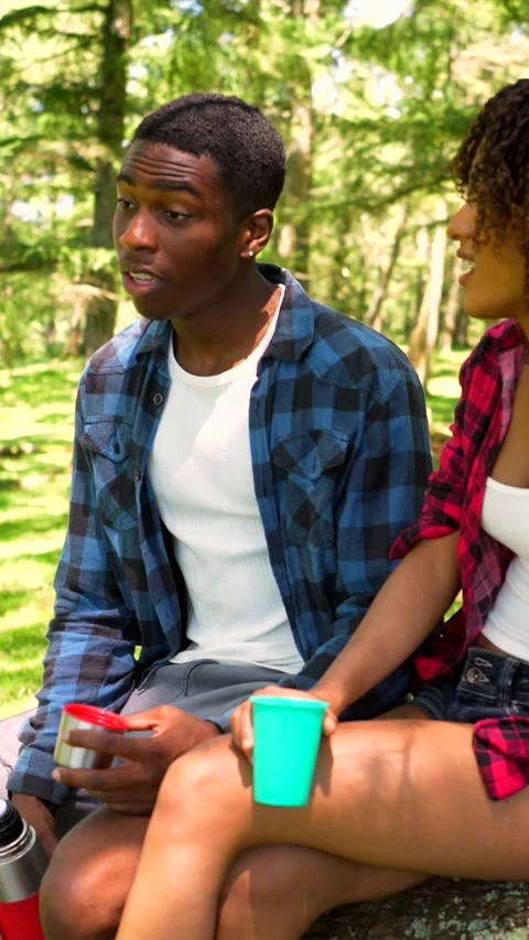 Young couple talking and drinking in a forest Stock Footage 313763391