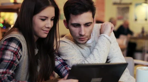 Young couple talking and using tablet computer in cafe HD Stock Footage 45352936
