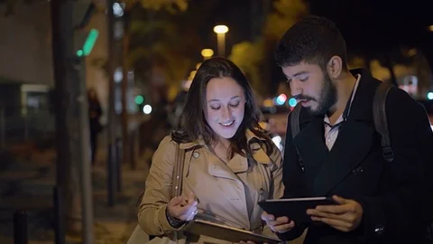 Young couple talking and using digital tablets on street Stock Footage 100890528