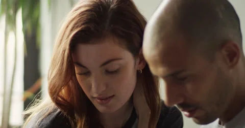 Young couple talking to each other while using laptop Stock Footage 63374129