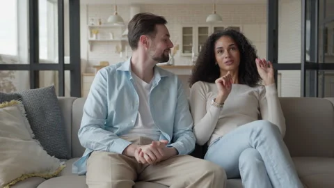 Young Couple Talking On Sofa While Woman Sharing Story At Home Stock-Footage 331788413