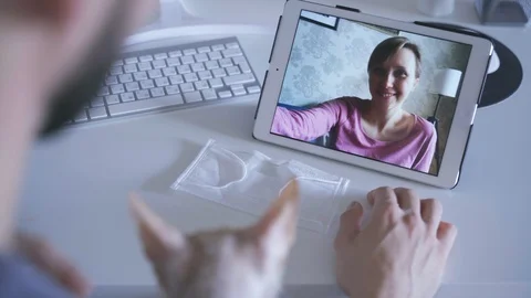Young couple is talking in video chat using tablet at table in modern apartment Stock Footage 127689108