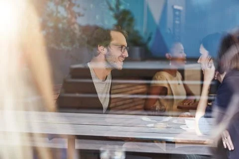 Young couple talking while on coffee date in busy cafe Stock Photos