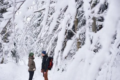 Young couple talking while hiking in a snow covered forest Stock Photos