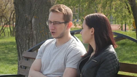 Young couple talking while sitting on the bench in the park 動画素材 90777366