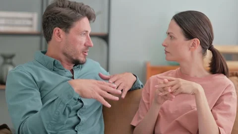 Young Couple Talking while Sitting on Sofa 動画素材 287412737