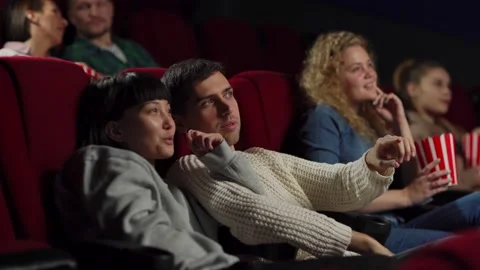 Young couple talking while watching movie in cinema Stock Footage 142337104