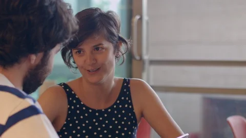 A young couple talks about some app in a coffee shop looking on the tablet 스톡 동영상 88464908