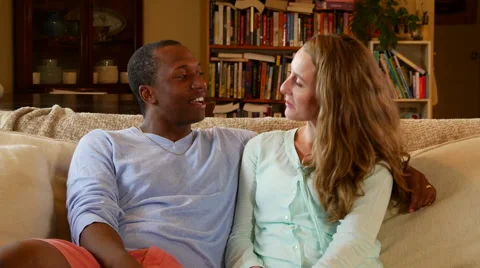 Young couple talks and laughs on couch Stock Footage 53014867
