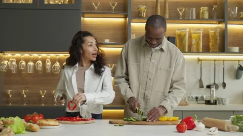Young couple talks cutting fresh vegetables for salad Stockbeeldmateriaal 170364102