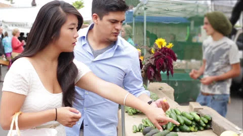 Young Couple Tasting Fruit and Vegetables at Farmers Market Stock Footage 27144813