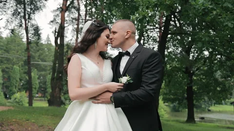 A young couple on their wedding day are hugging in the park. Happy newlyweds Stock Footage 252201251