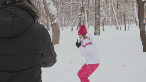 Young couple throwing snowballs in winter garden. Snowball fight Stock Footage 72302359