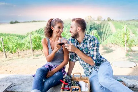 Young couple toasting in a vineyard at sunset Stock Photos